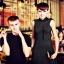 Placeholder: Russian guy student boy boyish boylike short man's haircut men's face boyish features female figure in black girlish lacy cocktail dress earrings in restaurant