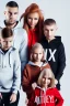 Placeholder: Posed shot of a beautiful european family with a mother with blonde hair dressed in workout clothes a father with brown hair dressed in sweatpants and a black zip up hoodie a young teenage boy with brown hair dressed in comfortable clothes a young woman with red hair and dressed like an egirl a young athletic boy with messy red hair dressed in popular clothes a messy looking 5 year old with red hair and a goofy smile a toddler with blonde hair dressed in pajamas