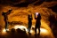 Placeholder: two women holding flashlights discovering a huge stone sarcophagus inside a cave