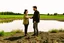 Placeholder: A picture of two people exchanging criticism in a constructive and respectful manner, standing on a land surrounded by dirt, and behind them a lake