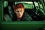 Placeholder: Photograph of a young rugged looking male with red hair and green eyes sitting in the drivers seat of a jeep close up photo realistic