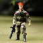 Placeholder: G.i. Joe toy camouflage khaki doll Donald Trump orange face with boots full body in package high resolution 2019, in a box with gun in jungle