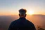 Placeholder: a brawny man with grey hair views sunset from a cliff