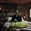 Placeholder: The lone, middle-aged man stands in a desolate messy bed. Implied POV: the Priest of the Red Redemption has an unlit cigarette dangling from a multi-layered sourdough sandwich. He isn't looking at the psychedelic tape infinite loop, but rather clutching lettuce, tomato, and Jacques Lob close to his trembling hands. Twilight in a raw 35mm photograph. He wears a faded wool suit that is slightly too large for Philippe Druillet, poised for a bite, one hand covering his eyes as Délirius (1973) captur