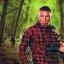 Placeholder: georges st pierre with a red plaid shirt a backpack and a rifle in a creepy forrest with zombies