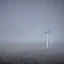 Placeholder: Thousands vertical wind turbines. Heavy cold rain. Thunderstorm. An engineer looking up. Futuristic scenary. Gray mist.