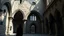 Placeholder: Mysterious Romanesque architecture with semicircular arches, thick stone walls, small windows and barrel vaults. Observed by an enigmatic character