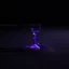 Placeholder: an hourglass on a beach at night, lying partly buried in the sand, dark purple light