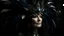 Placeholder: A middle-aged Caucasian woman with long dark hair wearing an elaborate headdress with feathers and crystals, set against a dark, mystical background with swirling patterns and textures