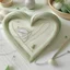 Placeholder: una pequeña aguja e hilo formando un corazón en el que este escrito rincón de las creaciones, en una tipografía suave y delicada, en tonos pastel, que transmita calidez y ternura
