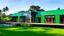 Placeholder: A vibrant single-family home stands out against a lush green backdrop. Its exterior is a playful patchwork of: Emerald green panels, Tangerine orange sections, Sky blue accents. Black steel beams form a striking geometric structure, framing large windows and creating an artistic, modern silhouette. Airy white fabric awnings gently billow in the breeze, softening the angular architecture. These airy elements provide shade over: A wide wooden deck. In the foreground, a natural-looking pond reflect