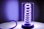 Placeholder: coiled tube with linear beggining and end, liquid droplets dropping from the end of the coil, white liquid enters the coil, a light bulb place above the coil is shining smooth gentle violet rays onto the coil