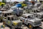 Placeholder: A light gray trashed junkyard with broken down construction vehicles designed in Oaxacan alebrijes painted by Keith Haring