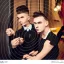 Placeholder: Russian guy student boy boyish boylike short man's haircut men's face boyish features female figure in black girlish lacy cocktail dress earrings in restaurant