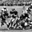 Placeholder: Boston Shamrocks Football team playing against the Toronto Rifles Football team,vintage footage, hyper-realistic