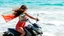 Placeholder: A woman on a motorcycle, a symphony of colour and motion, against a vibrant ocean.