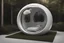 Placeholder: realistic photograph futuristic pod, ceramic aluminum orb pod with window. white walls and hands.