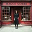 Placeholder: Photorealistic image of a young woman with dark hair, in a black ankle length skirt, boots and shirt, standing outside an old magic shop front with large red painted multi-paned picture windows on either side of a multi-paned doorway.