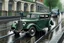 Placeholder: a vintage Bentley 4 door saloon with a border collie at the wheel driving the car is going down a very rainy London street. Photorealistic