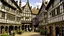 Placeholder: A Paved Courtyard, With Tudor Gothic Houses, Tall twisted Chimneys, warped Rooves, People, Shops,