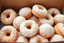 Placeholder: a box of fresh old-fashioned mini doughnuts completely covered in powdered sugar