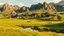 Placeholder: Resilient village among natural rock formations, fertile grasslands flourishing over former battlefield, serene pond lined with weeping willows, peaceful herds reclaiming once disputed land, traditional architecture integrated with historic defensive elements, golden light bathing the scarred landscape, post-war naturalism style