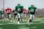 Placeholder: Boston Shamrocks Football team playing against the Toronto Rifles Football team,vintage, hyper-realistic, in color, Boston in green, Toronto in Red