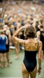 Placeholder: anorexic beautiful woman, age 21, total shot, anthracite triathlon swimsuit, medium long wavy bob haircut, brunette hair, blurred party crowd in background