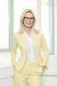 Placeholder: Powerful classical portrait of a modern blonde politician with glasses in her mid 40s wearing a pastel yellow pant suit standing in a elegant position. she looks kinda and have a soft smile