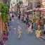 Placeholder: A magical street, a cobblestone street, shops and vendors on both sides of the street, unicorns on the street, little forest fairies flying, a minotaur eating ice cream, a baby gorgon playing soccer.