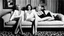 Placeholder: [photo by Helmut Newton (1965)] three women: Marilyn Monroe on a sofa with two friends, a brunette on her left, a redhead on her right