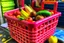 Placeholder: A pink plastic basket with a handle inside this basket contains mobile phones, lettuce, tomatoes, cassette tapes, and puppets, and this basket is next to a newspaper kiosk. like oil painting