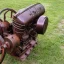 Placeholder: Old, small, simple, brown single-cylinder engine