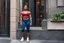 Placeholder: muscular unhappy woman on the doorstep of an apartment in NY