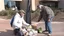 Placeholder: dirty homeless man receiving cash for his groceries to strangers