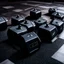 Placeholder: Hexagon dumbbells pair of two, each 12.5KG. Inside a gym on the black rubber tile floor. Bird perspective on the dumbbells laying on the floor.