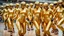 Placeholder: Hyperrealistisch dutzende Rollergirls völlig verhüllt von golden glänzendem Ganzkörper-Zentai mit geschlossenem Visier in identischen goldfarbenen, geschlossenen Helmen fahren in Steilkurve in Formation parallel nebeneinander und hintereinander mit Rollschuhen