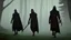 Placeholder: Black robed, hooded monks on the forest path