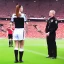 Placeholder: Sue Bird in a referee jersey officiating for a soccer match at Wembley Stadium