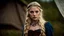 Placeholder: Photo is in sharp focus with high resolution. It is is a closeup portrait of a beautiful and slender caucasian 16 year old teen girl with long wavy platinum blonde hair. She has full lips, a turned up nose, arched eyebrows and large blue eyes. She is wearing a viking dress with a corset and in a Viking camp in Norway. She is gazing at the viewer.