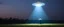 Placeholder: flying saucer ufo in autumn evening field shooting a cone of light upwards to the sky down to another saucer standing in the field