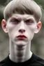 Placeholder: pale skin tone, black hair in a longish bowl cut with whisps in front of his ears, face is thin with high cheekbones and deep blue eyes that are often full of emotion and full lips. lean build that suggests he doesn't engage in a lot of physical activity. He is of average attractiveness with a boyish face.