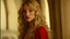 Placeholder: Photo is in sharp focus with high resolution during the middle of day and is a closeup of a beautiful and slender caucasian 17 year old girl with long wavy blonde hair. She has a small upturned nose, full lips, large dark eyes and with long eyelashes. She is wearing a red corset. She is in a castle room gazing at the viewer.