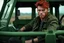 Placeholder: young rough and rugged male photorealistic red hair and green eyes smirking expression sitting in a jeep