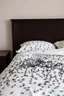 Placeholder: A king size bed with white sheets covered with black ants