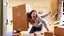 Placeholder: woman starts frantically tearing through a very large door sized box the kitchen table was delivered in