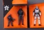 Placeholder: Mike pence G.i. Joe toy doll space force uniform inside a blister package hanging on A rack in toystore, fluorescent orange, wide angle shot whole body, black moonboots