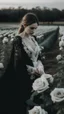 Placeholder: black lace scarf and dirty white wedding dress in a field of white roses.cinematic picture