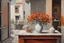 Placeholder: An oil painting depicts an indoor scene. On the left side of the picture is a white vase with white and red flowers in it. Below the vase seems to be a table or a counter. On the right side of the background is part of a building, showing orange and gray tones, with clothes hanging out to dry on the building. The whole picture is rich in color, with rough brushwork, giving a warm and vivid feeling.