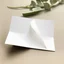 Placeholder: A photo of a white folded card, 5.5 by 4.25 inches. The card is laying vertically on a beautiful white surface.